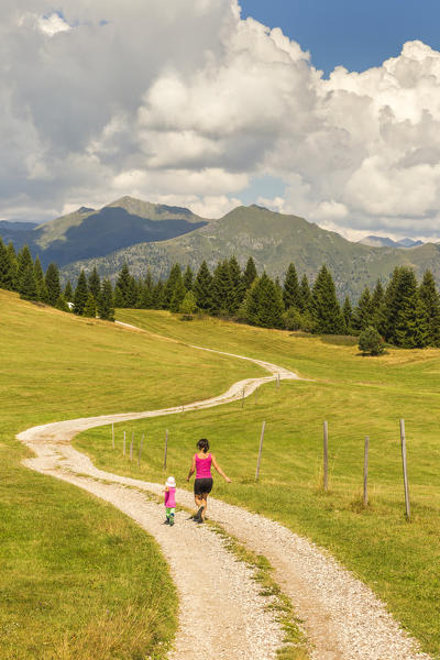 Mom with her daughter runs on the Non valley paths, Cles, Trento province, Trentino Alto Adige, Italy, Europe (MR)