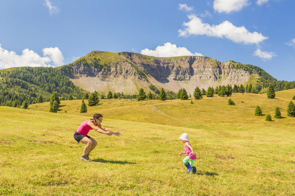 Mom with her daughter have fun on meadows of the Non valley, Cles, Peller mount, Trento province, Trentino Alto Adige, Italy, Europe (MR)