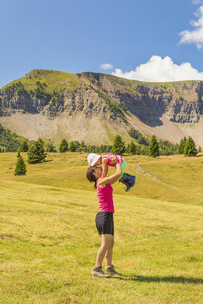 Mom with her daughter have fun on meadows of the Non valley, Cles, Peller mount, Trento province, Trentino Alto Adige, Italy, Europe (MR)