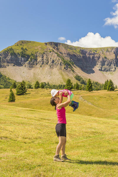 Mom with her daughter have fun on meadows of the Non valley, Cles, Peller mount, Trento province, Trentino Alto Adige, Italy, Europe (MR)