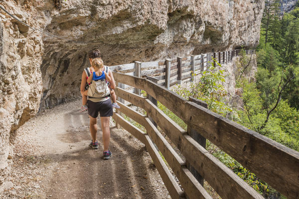 Hiker with son crosses the canyon to reach San Romedio monastery, sentiero delle forre, Sanzeno, Predaia, Non valley, Trento province, Trentino Alto Adige, Italy, Europe (MR)