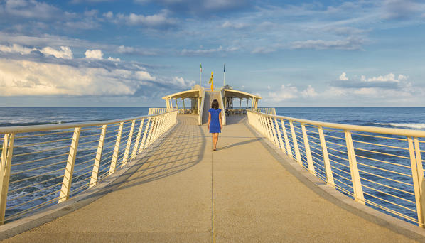 Girl walks on Lido di Camaiore pier, Lucca province, Versilia, Tuscany, Italy, Europe (MR)