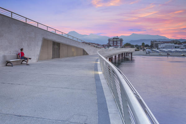 A tourist looks sunrise on Lido di Camaiore pier, Lucca province, Versilia, Tuscany, Italy, Europe