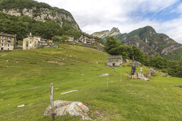 Hiker with daughter reaches Dasile village, Piuro, Chiavenna valley, Sondrio province, Lombardy, Italy, Europe (MR)