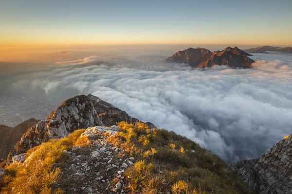 Sunrise on Lecco mountains (Corni di Canzo, Rai, Moregallo) wrapped of clouds from the top of Coltignone mount, Piani dei Resinelli, Lecco province, Lombardy, Italy, Europe