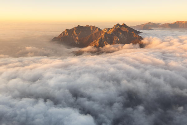 Sunrise on Lecco mountains (Corni di Canzo, Rai, Moregallo) wrapped of clouds from the top of Coltignone mount, Piani dei Resinelli, Lecco province, Lombardy, Italy, Europe