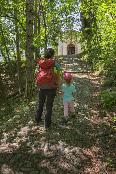 Mom and daughter walking on the path to reaching San Martino church, Griante, lake Como, Como province, Lombardy, Italy, Europe (MR)