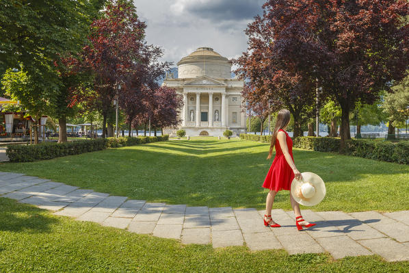 A tourist walking on Como gardens and looks a Volta Temple monument (Tempio Voltiano), Como city, Lombardy, Italy, Europe (MR)