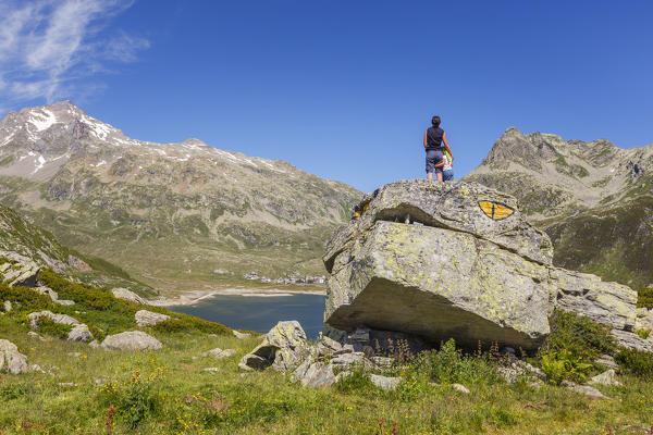 Mom and son looks the mountains and Montespluga lake on the rock called Snake of Montespluga, Madesimo, Sondrio province, Spluga valley, Lombardy, Italy, Europe (MR)