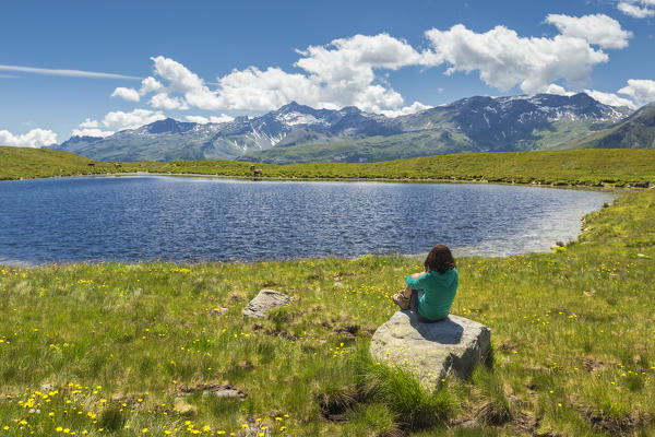 Hiker take relax and looks Andossi lake, Montespluga, Madesimo, Sondrio province, Spluga valley, Lombardy, Italy, Europe (MR)