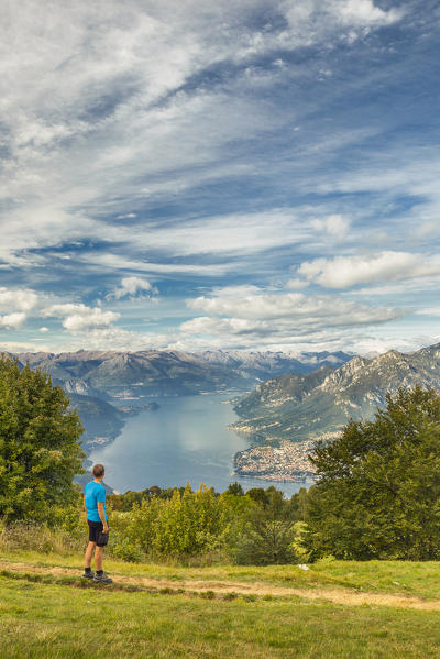 Hiker looks lake Como (ramo di Lecco) from the path of Sev refuge, Valbrona, Corni di Canzo, Como and Lecco province, Lombardy, Italy, Europe (MR)