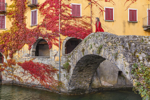 A tourist on the Ponte della Civera looks lake Como from Nesso village in Autumn time, Como province, Lombardy, Italy, Europe (MR)