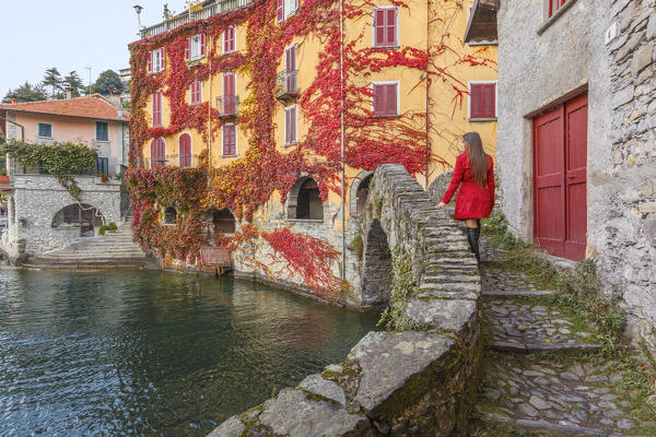 A tourist on the Ponte della Civera looks lake Como from Nesso village in Autumn time, Como province, Lombardy, Italy, Europe (MR)