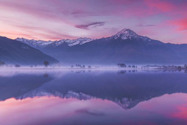 Sunrise on Legnone mount (Lecco province) reflected into Mera river from Dascio village, Sorico, Riserva Naturale Pian di Spagna e Lago di Mezzola, lake Como, Como province, Lombardy, Italy, Europe