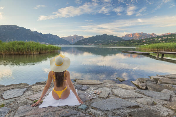Girl relaxes and looks reflections into the Oggiono lake in summertime, Annone lake, Oggiono, Brianza, Lecco province, Lombardy, Italy, Europe (MR)