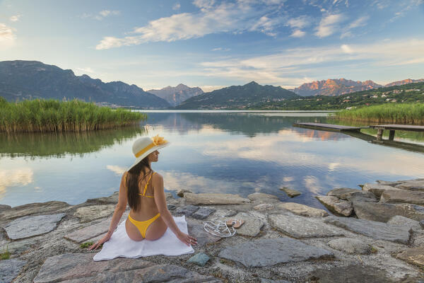 Girl relaxes and looks reflections into the Oggiono lake in summertime, Annone lake, Oggiono, Brianza, Lecco province, Lombardy, Italy, Europe (MR)