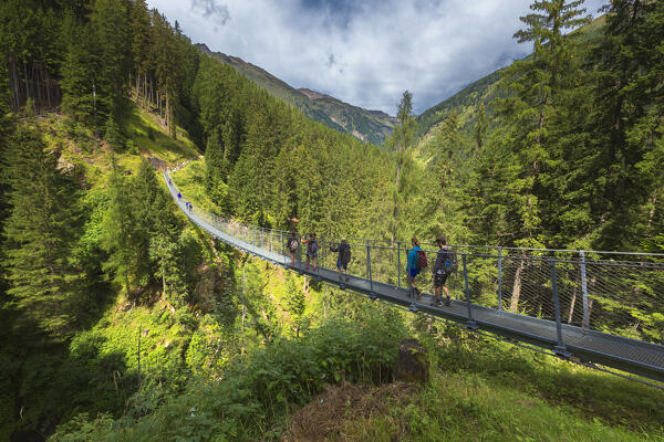 People cross the tibetan bridge (Ponte Sospeso Ragaiolo), Rabbi valley (val di Rabbi), Trento province, Trentino-Alto Adige, Italy, Europe