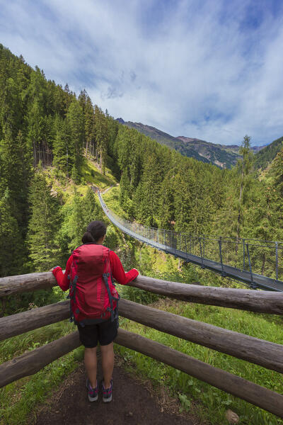 Hiker looks the tibetan bridge (Ponte Sospeso Ragaiolo), Rabbi valley (val di Rabbi), Trento province, Trentino-Alto Adige, Italy, Europe (MR)