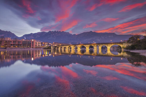 Sunrise on Lecco mountains (Resegone) reflected into the Adda River, Azzone Visconti bridge, Lecco city, lake Como, Lombardy, Italy, Europe
