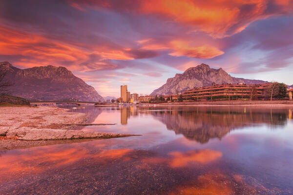 Sunrise on Lecco mountains (Coltignone, Moregallo) reflected into the Adda River, Lecco city, lake Como, Lombardy, Italy, Europe