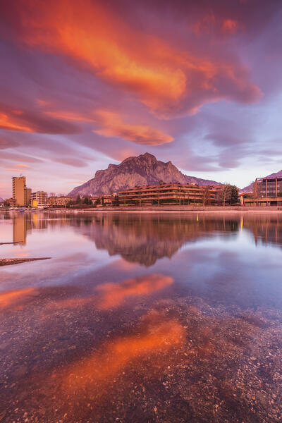 Sunrise on Lecco mountains (Coltignone) reflected into the Adda River, Lecco city, lake Como, Lombardy, Italy, Europe