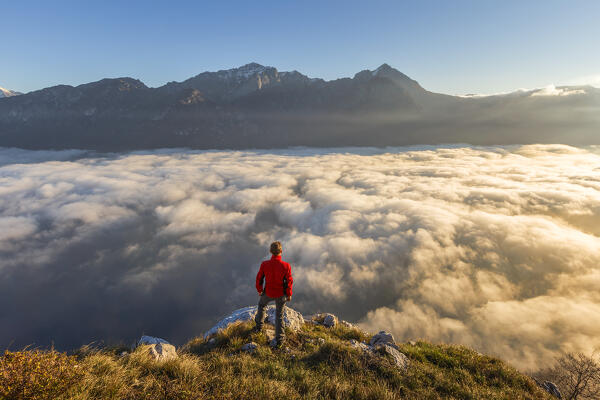 Hiker looks Grigna group and lake Como (ramo di Lecco) covered by the fog, Barni, Como and Lecco province, Lombardy, Italy, Europe (MR)
