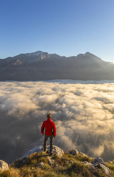 Hiker looks Grigna group and lake Como (ramo di Lecco) covered by the fog, Barni, Como and Lecco province, Lombardy, Italy, Europe (MR)
