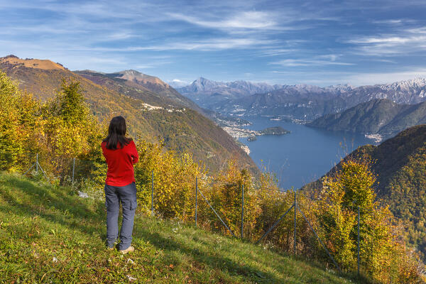 Woman looks lake como from San Zeno church in autumn time. Cerano d'Intelvi, Intelvi valley (val d'Intelvi), lake Como, Como province, Lombardy, Italy, Europe (MR)