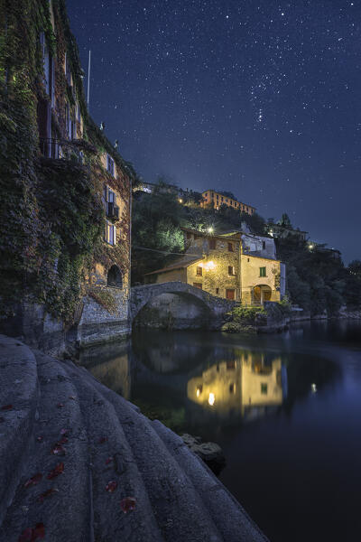 Nesso village illuminate in the night under the starry sky, lake Como, Como province, Lombardy, Italy, Europe