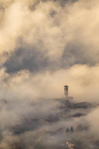 St. Stephen church (chiesa di piazza S. Stefano) wrapped by the morning fog, Cernobbio town, lake Como, Como province, Lombardy, Italy, Europe