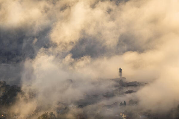 St. Stephen church (chiesa di piazza S. Stefano) wrapped by the morning fog, Cernobbio town, lake Como, Como province, Lombardy, Italy, Europe