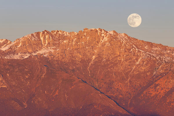 The full moon rises above Zucco Barbisino mount, Zucco Orscellera mount and Zuccone Campelli mount at sunset.
Bergamasque prealps, Valsassina, L ecco province, Lombardy, Italy, Europe