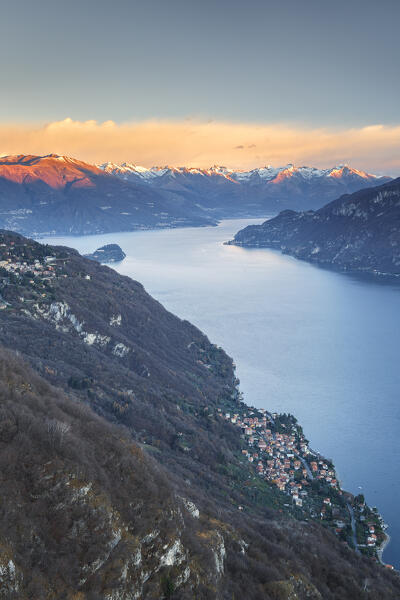 First ray of sunshine on lake Como (ramo Lecco) and Alps. Oliveto Lario village, Como province, Lombardy, Italy, Europe