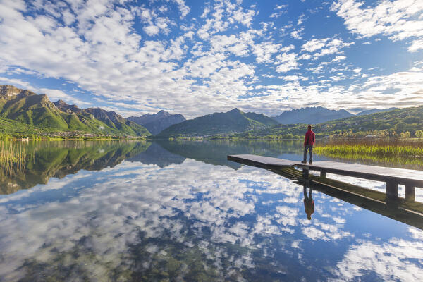 Man looks the morning reflections on Annone lake, Brianza, Lecco province, Lombardy, Italy, Europe (MR)