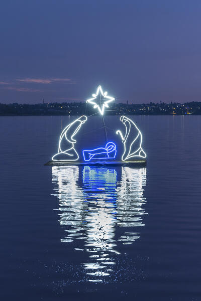 The reflections of lights of floating nativity scene on Pusiano lake, Pusiano, Brianza, Como province, Lombardy, Italy, Europe