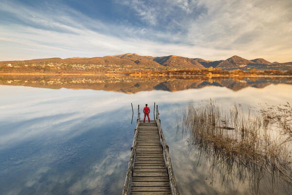 Hiker on the pier looks Alserio lake, Brianza, Parco regionale della Valle del Lambro, Como province, Lombardy, Italy, Europe (MR)