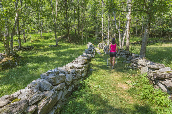 A trekker walking on the Via Spluga path from Vho village of San Giacomo Filippo to Campodolcino, Chiavenna valley, Sondrio province, Lombardy, Italy, Europe (MR)