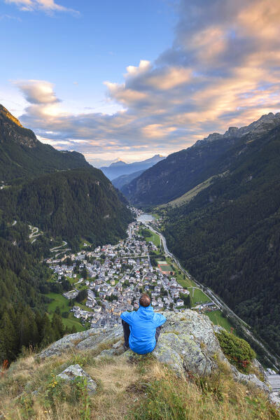 Hiker take relax look at the sunset on Campodolcino village and Spluga valley, Sondrio province, Lombardy, Italy, Europe (MR)