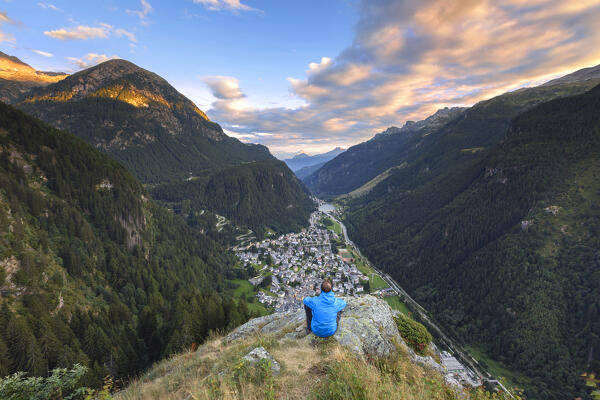 Hiker take relax look at the sunset on Campodolcino village and Spluga valley, Sondrio province, Lombardy, Italy, Europe (MR)