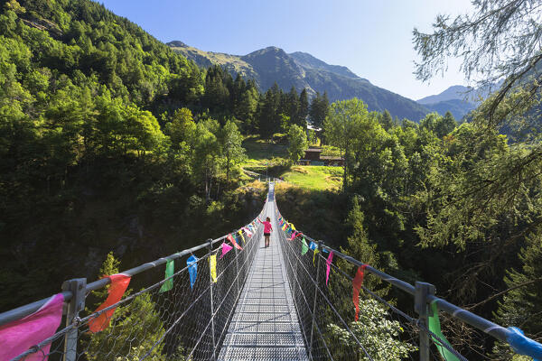 A child crosses the tibetan bridge of Fraciscio, Campodolcino, Spluga valley, Sondrio province, Lombardy, Italy, Europe (MR)