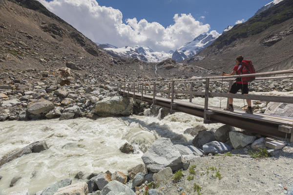 Hiker crosses the bridge, Morteratsch glacier, Bernina group, Morteratsch valley, Engadine, Switzerland, Europe (MR)