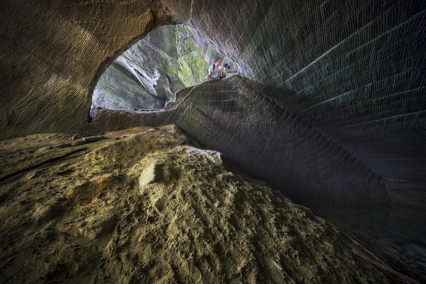 Photographer inside a cave of molera stone, valle del lanza, Malnate, Varese province, Lombardy, Italy, Europe