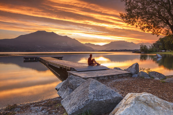 Man admire a fire sunrise on lake Pusiano, Como and Lecco province, Brianza, Lombardy, Italy, Europe (MR)
