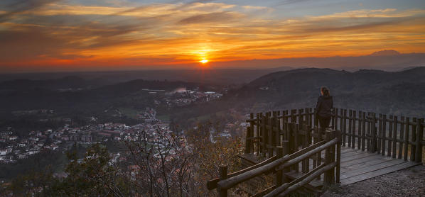 Girl admire a sunset and Cavallasca city on the balcony of Spina Verde, Como province, Lombardy, Italy, Europe (MR)