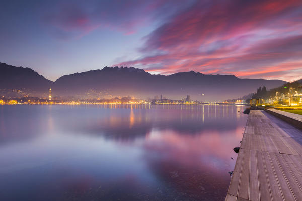 Lights of Lecco and mountains during a fiery sunrise, Lecco, lake Como, Lombardy, Italy, Europe