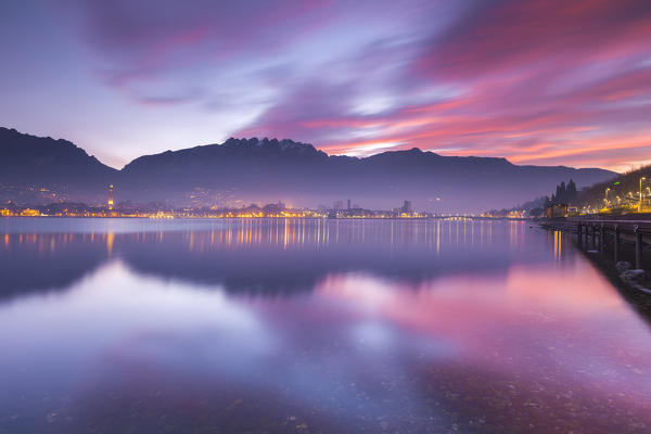 Lights of Lecco and mountains during a fiery sunrise, Lecco, lake Como, Lombardy, Italy, Europe