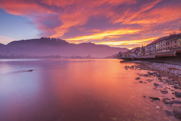 Fire sunrise on Lecco and mountains from Malgrate lakefront, lake Como, Lombardy, Italy, Europe