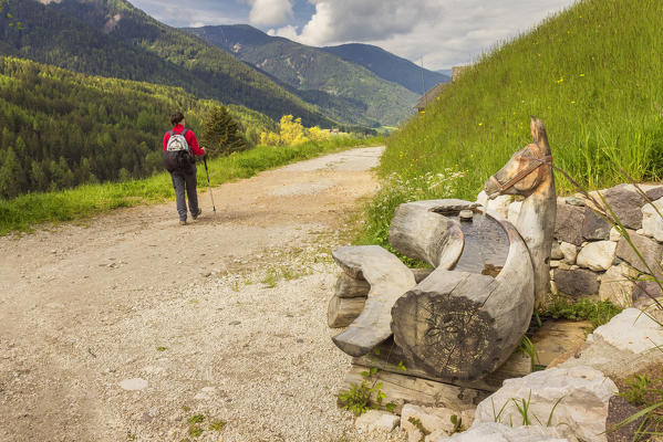 Hiker walks on path, Santa Magdalena, Funes valley, South Tyrol, Trentino Alto Adige, Bolzano province, Italy, Europe (MR)