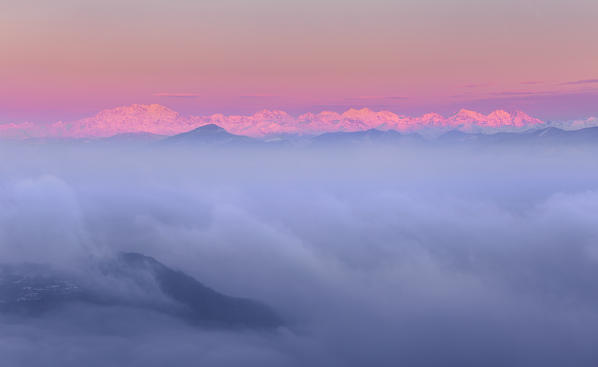 Rosa Mount and other peaks from alps rise up from a sea of clouds at sunrise. View from Brunate town (Como province, Lombardy, Italy, Europe)