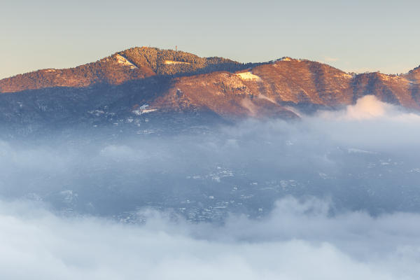 Bisbino mount rise up from a sea of clouds at sunrise, Como province, Lombardy, Italy, Europe